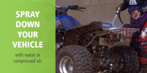 recreational ATV rider sprays down blue ATV with PlayCleanGo message: "spray down your vehicle"